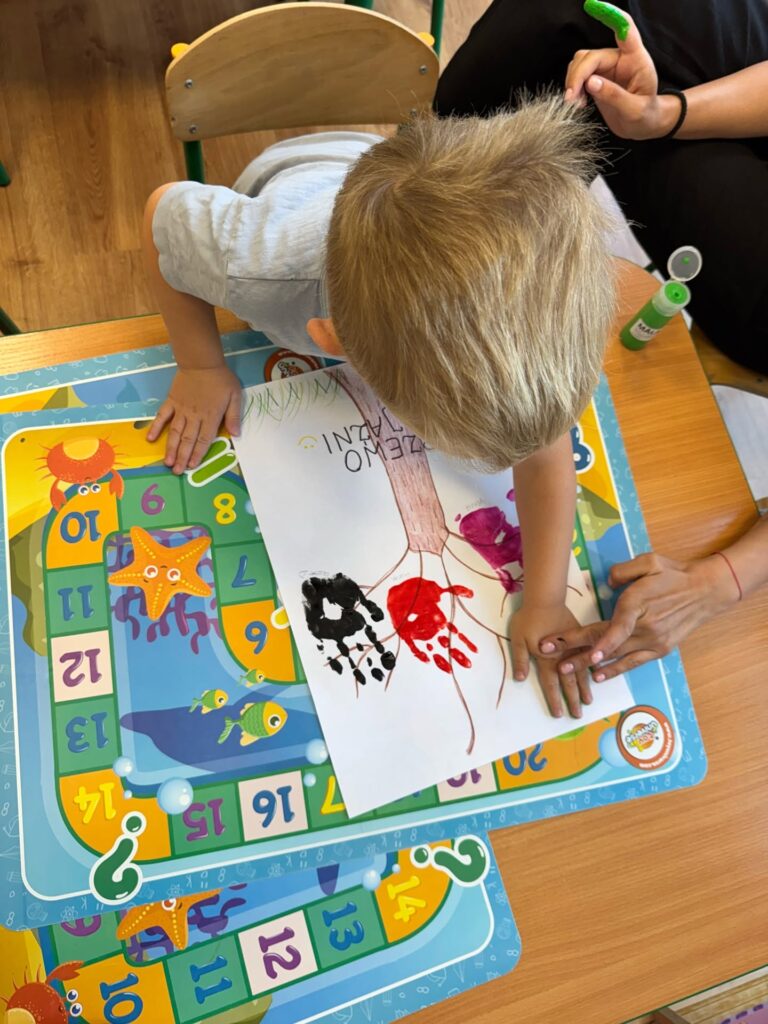Dziecko wykonuje pracę plastyczną Drzewo Przyjaźni w przedszkolu Niebieska Przystań